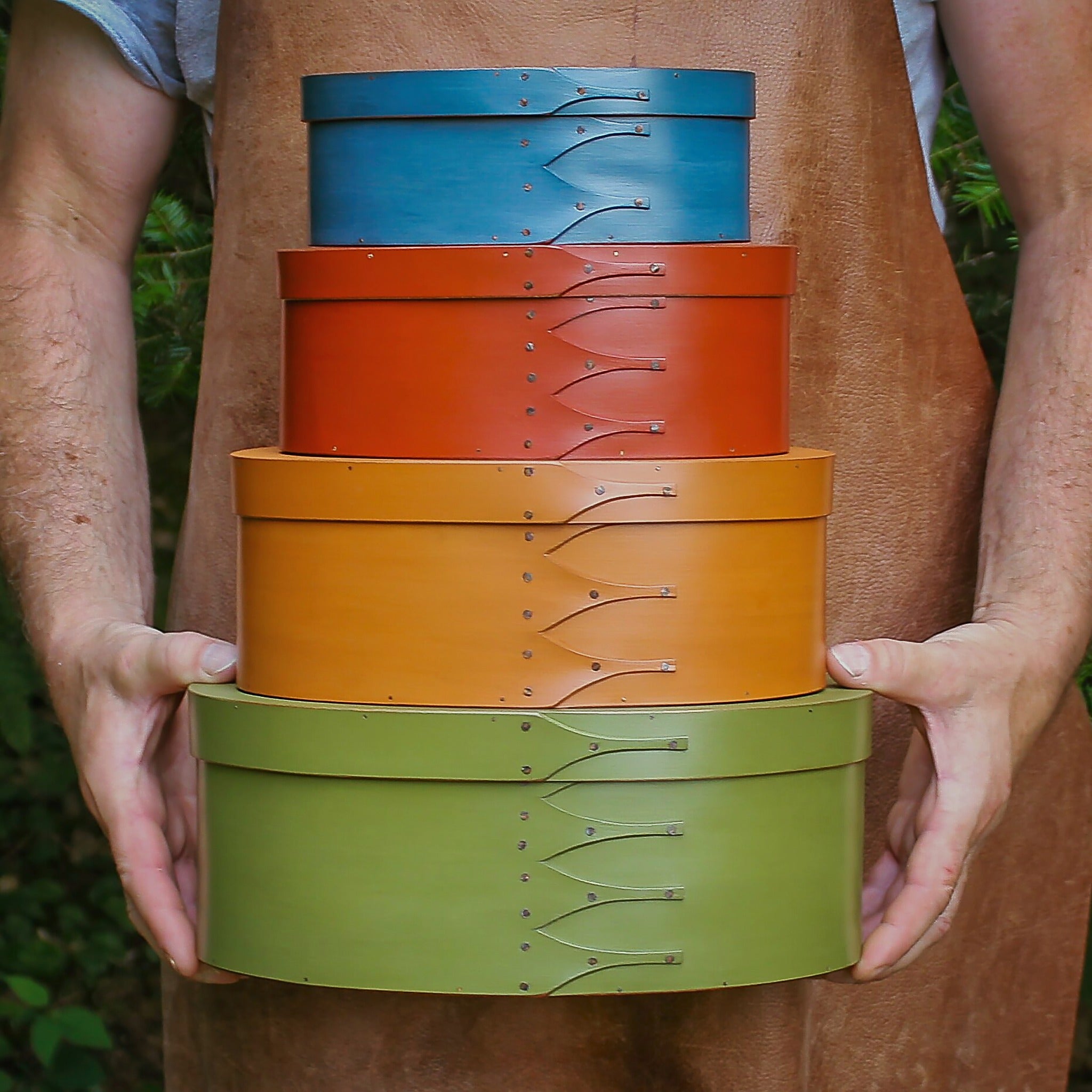 A graduated stack of painted oval boxes