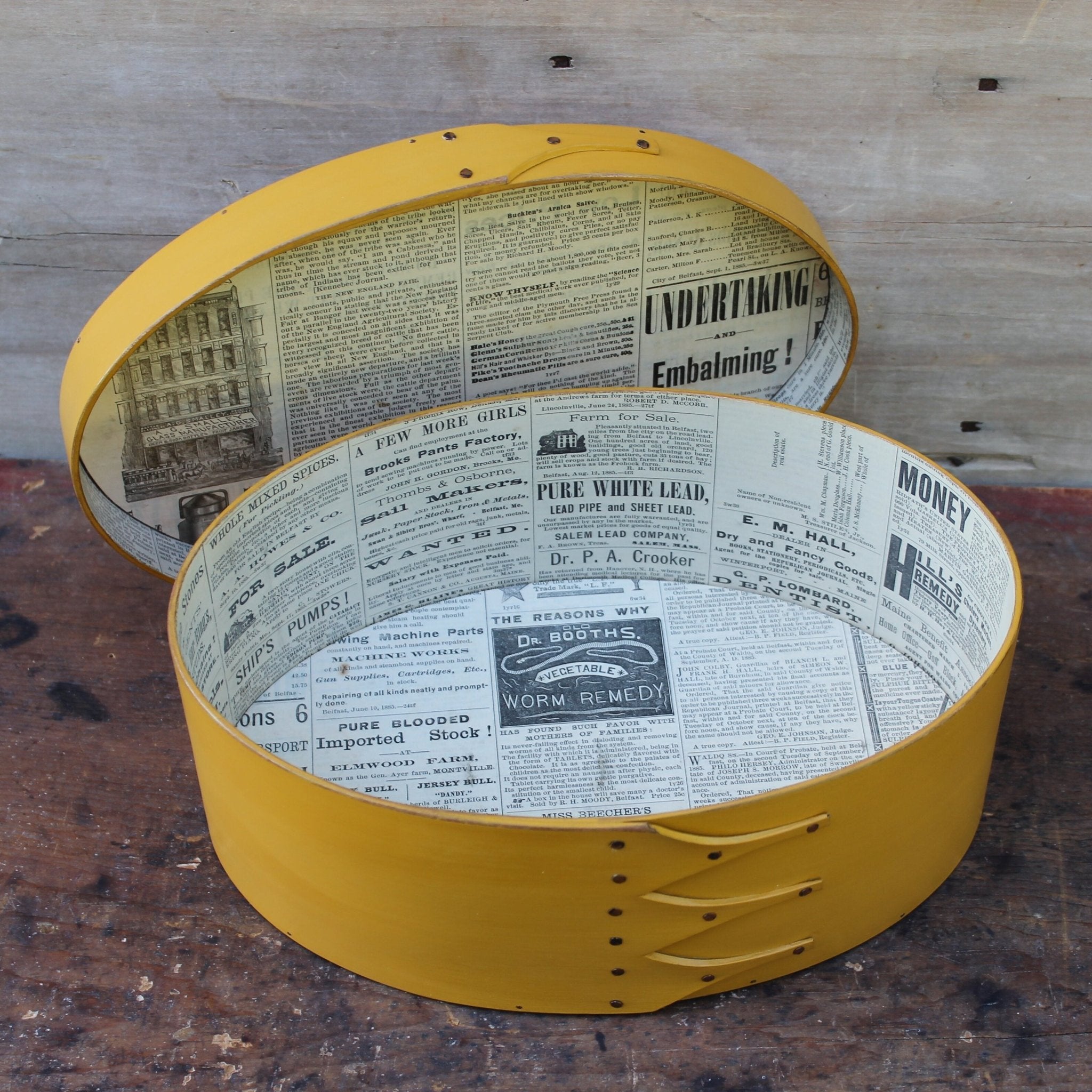 Shaker box with vintage 19th century newspaper lining, yellow milk paint finish.