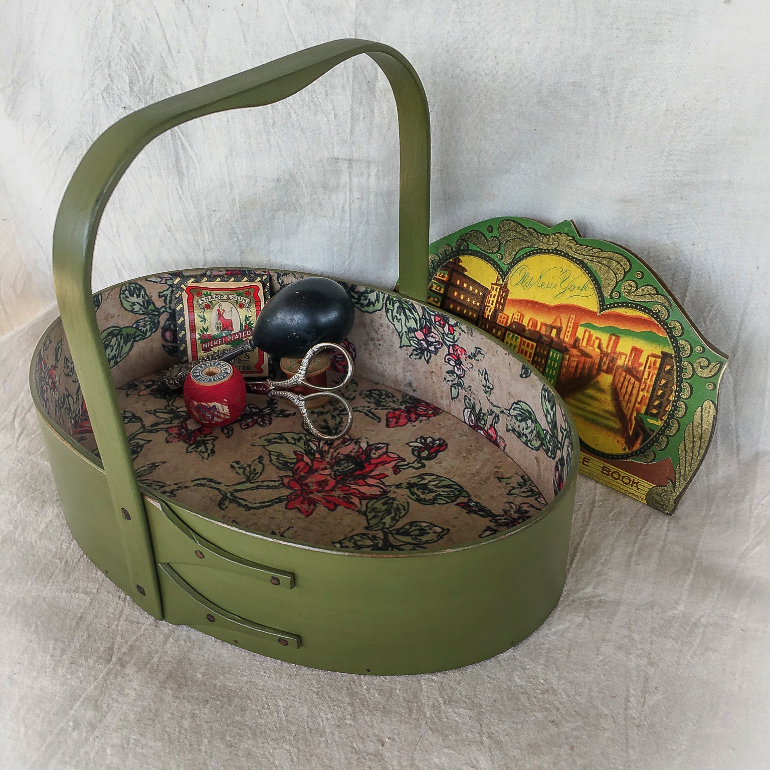 Oval handcrafted Shaker carrier with paper lining, for sewing or storage.