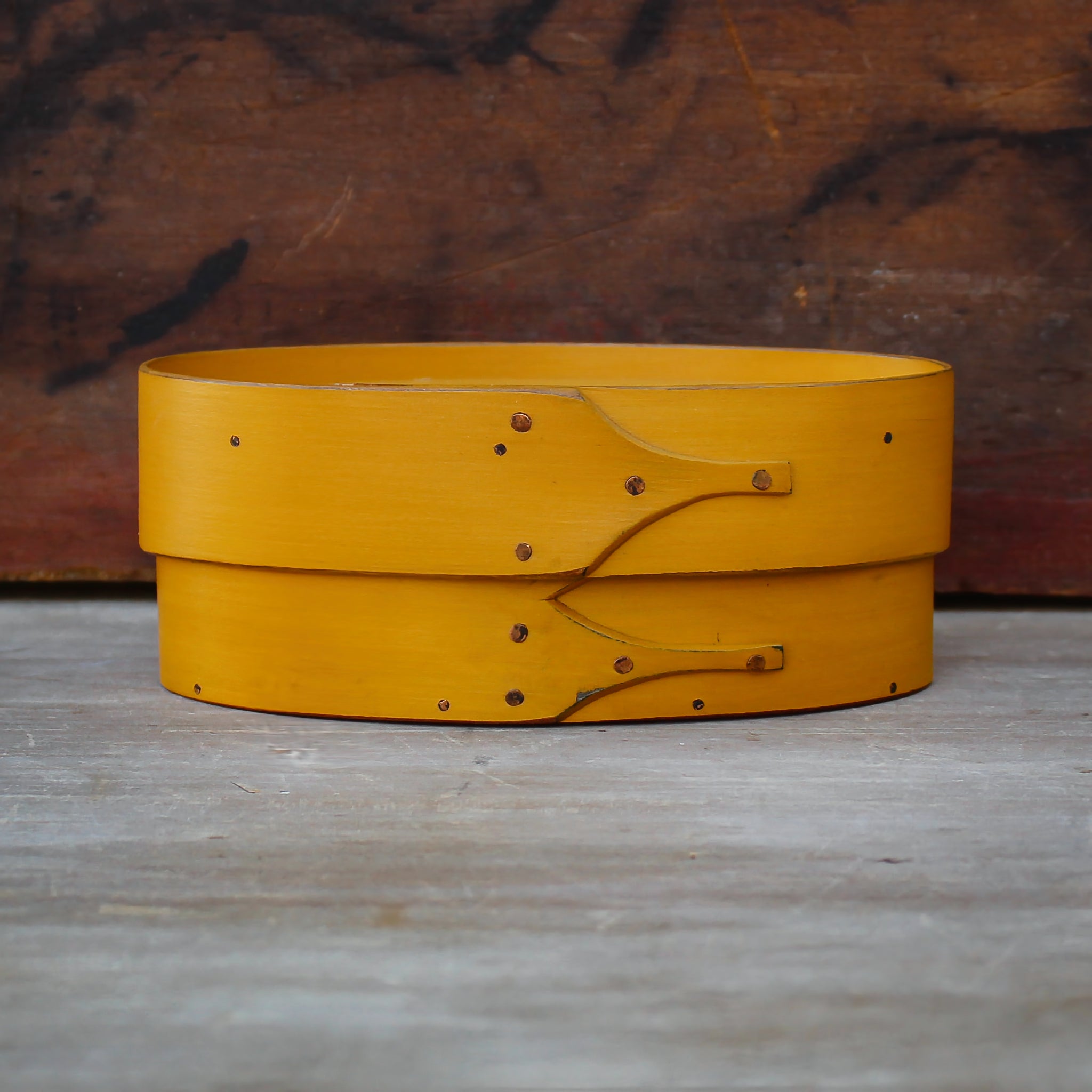 Handcrafted Shaker box in yellow; an oval sewing box made in Maine, featuring distinct wooden construction.