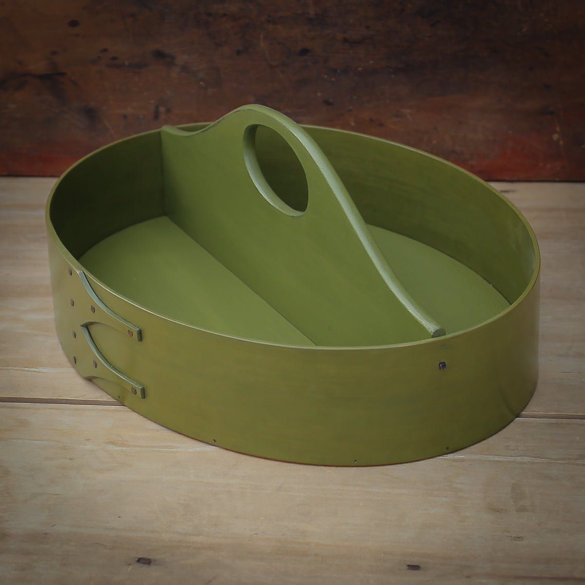 Green oval shaker carrier, handcrafted in Maine, features a fixed handle, ideal as a sewing organizer.