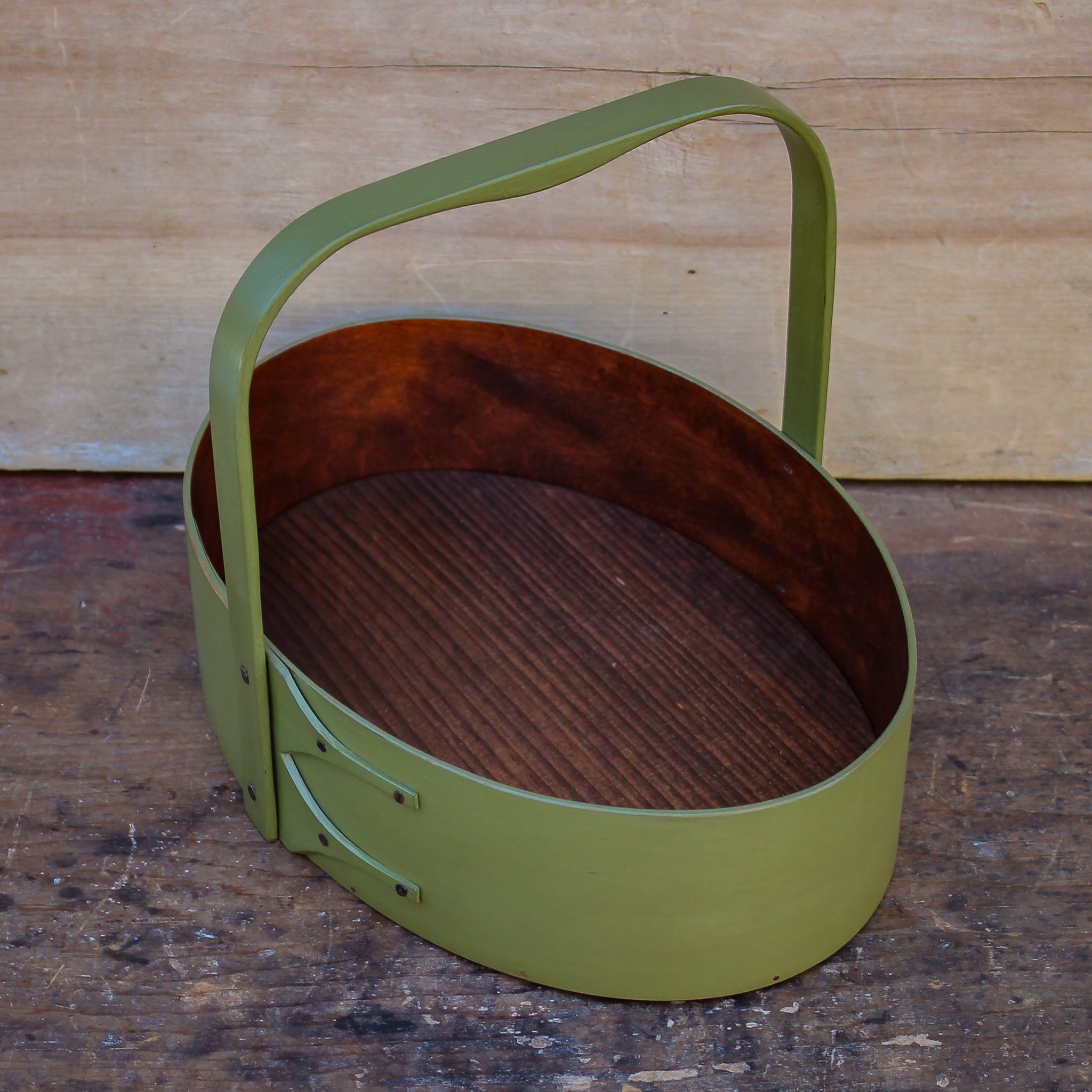 Handcrafted wooden basket in green, ideal as a shaker carrier or sewing organizer for desktop organization.
