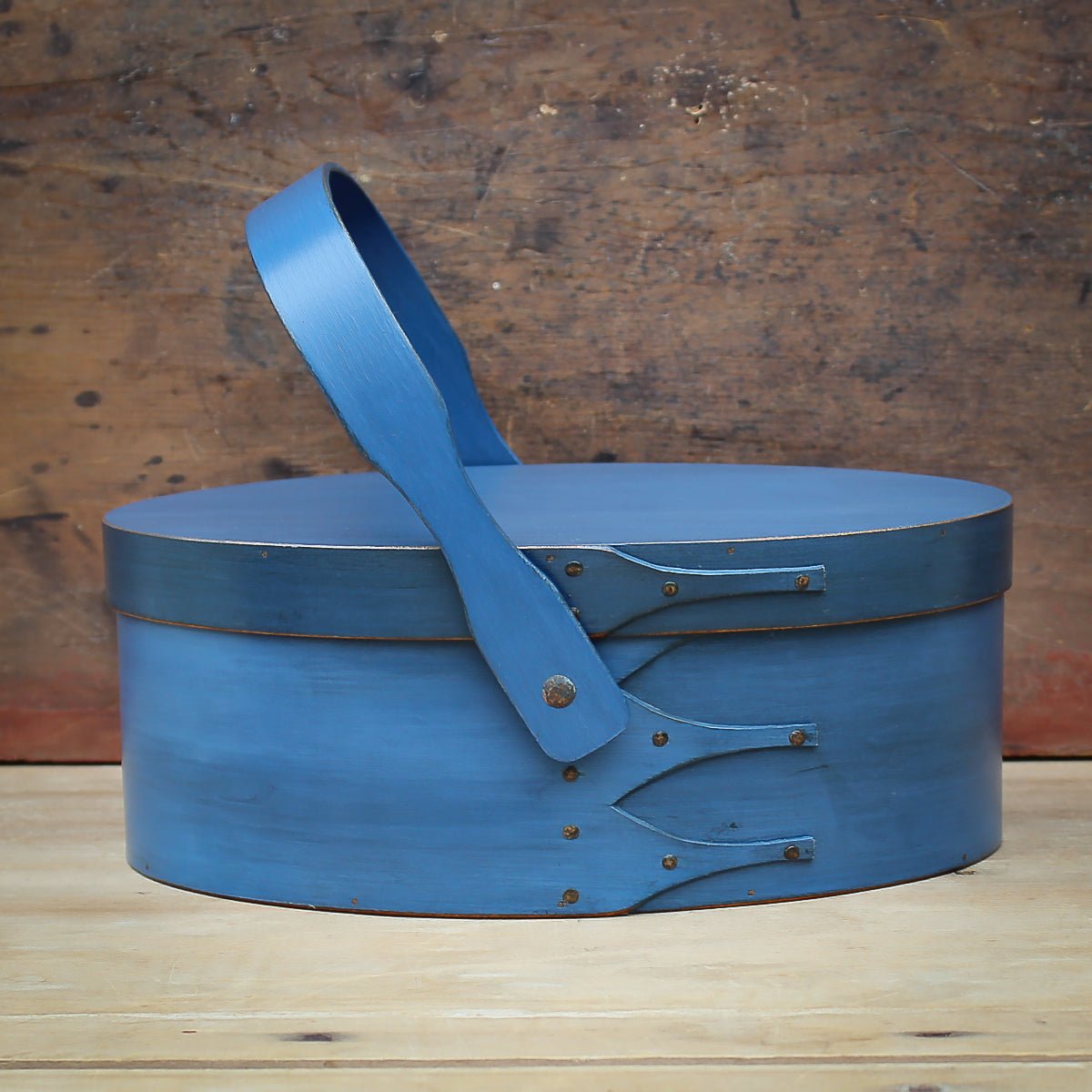 Handcrafted wooden sewing basket in traditional Shaker style with swing handle carrier, made in Maine.
