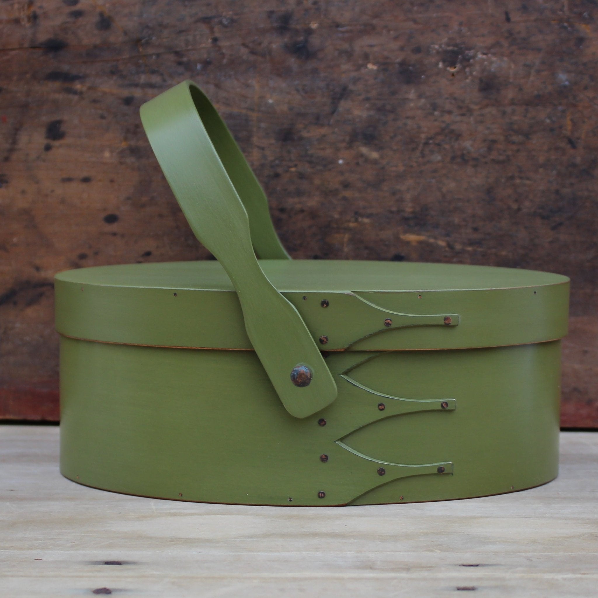 Handcrafted wooden sewing basket in traditional Shaker style, featuring a swing handle, made in Maine.