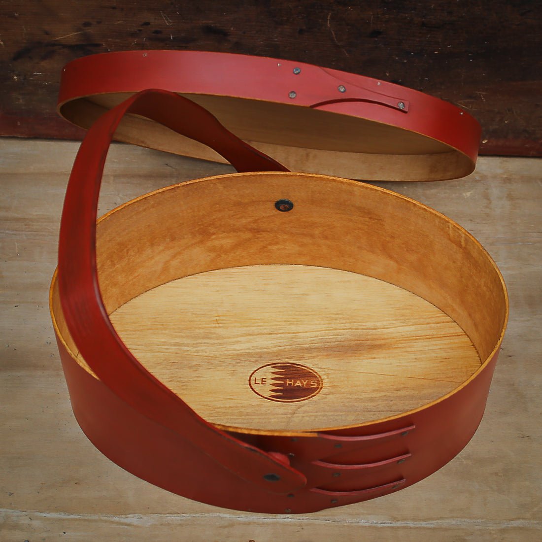 Handcrafted wooden sewing basket with Shaker swing handle carrier, featuring a traditional design from Maine.