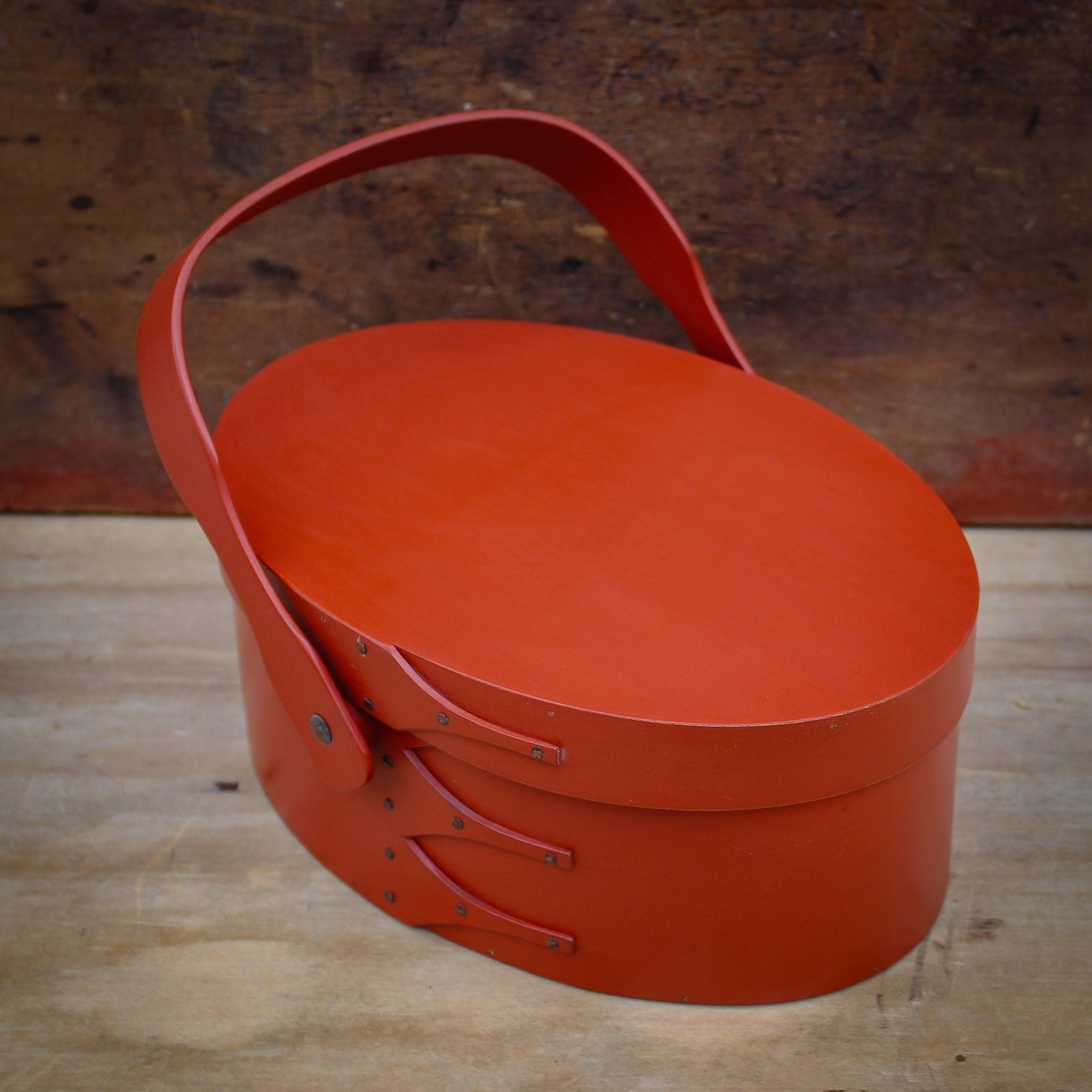 Handcrafted wooden sewing basket in traditional Shaker style, featuring a swing handle, made in Maine.