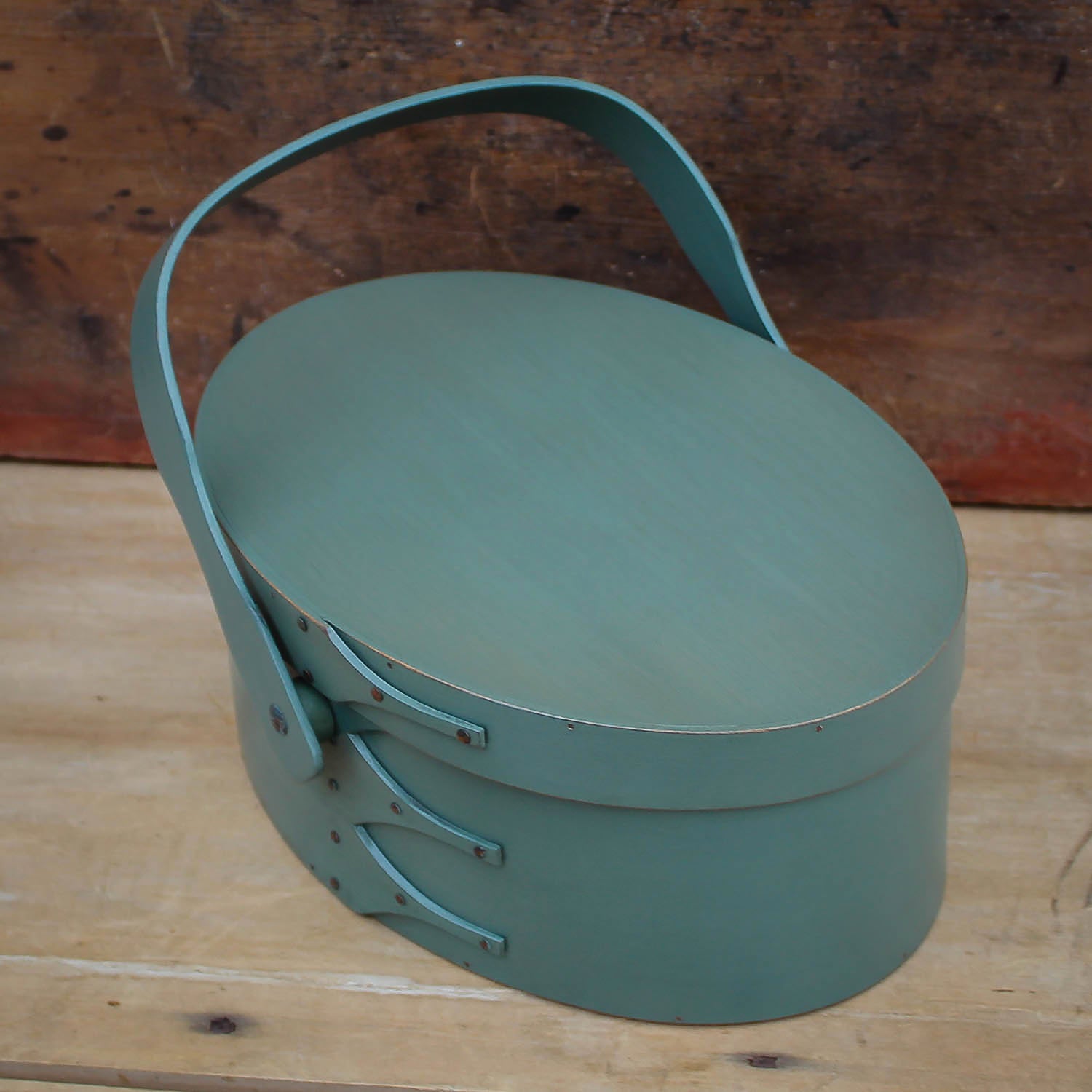 Handcrafted wooden sewing basket in traditional Shaker style, featuring a swing handle, made in Maine.