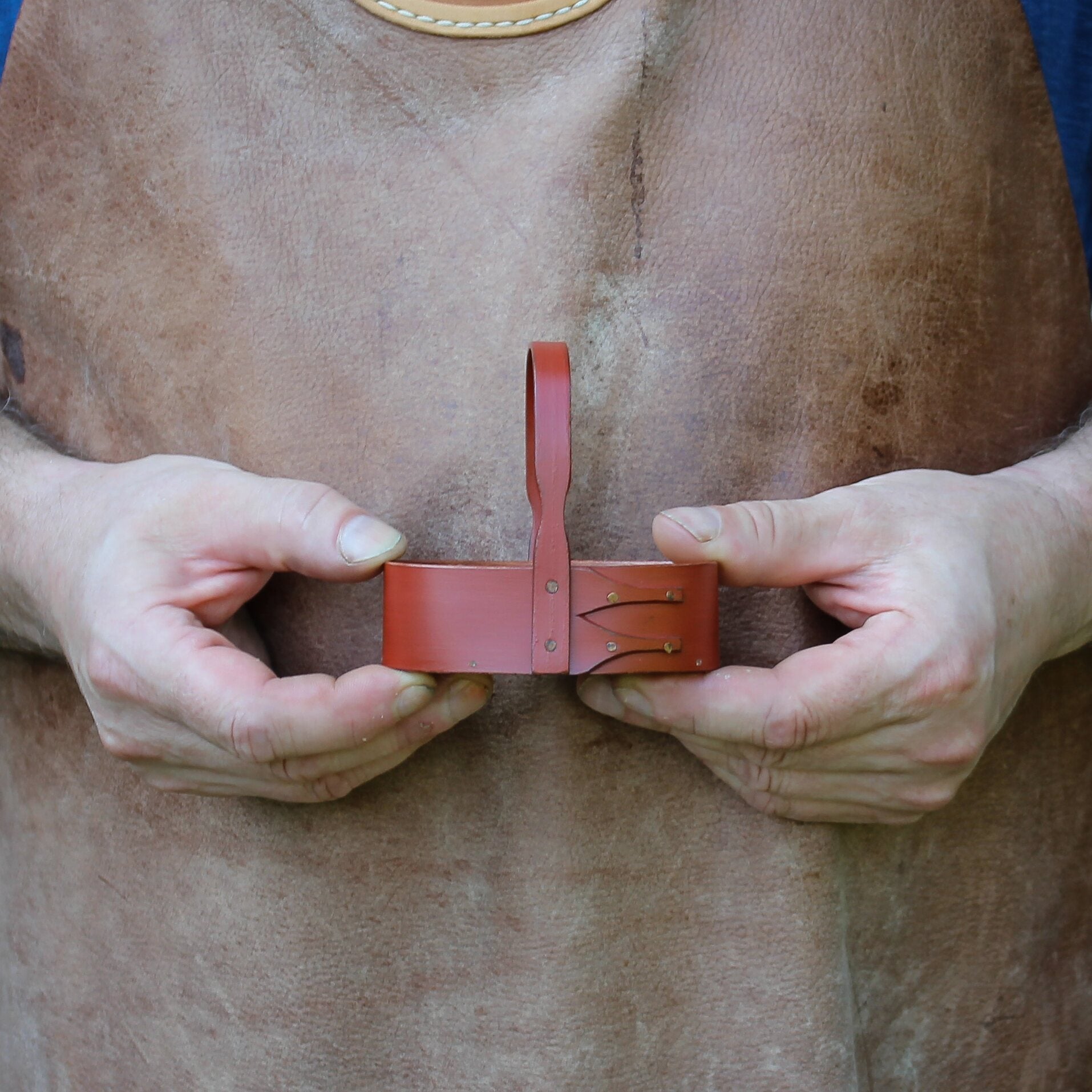 Person holding a handcrafted shaker carrier, showcasing artisanal detail and craftsmanship.