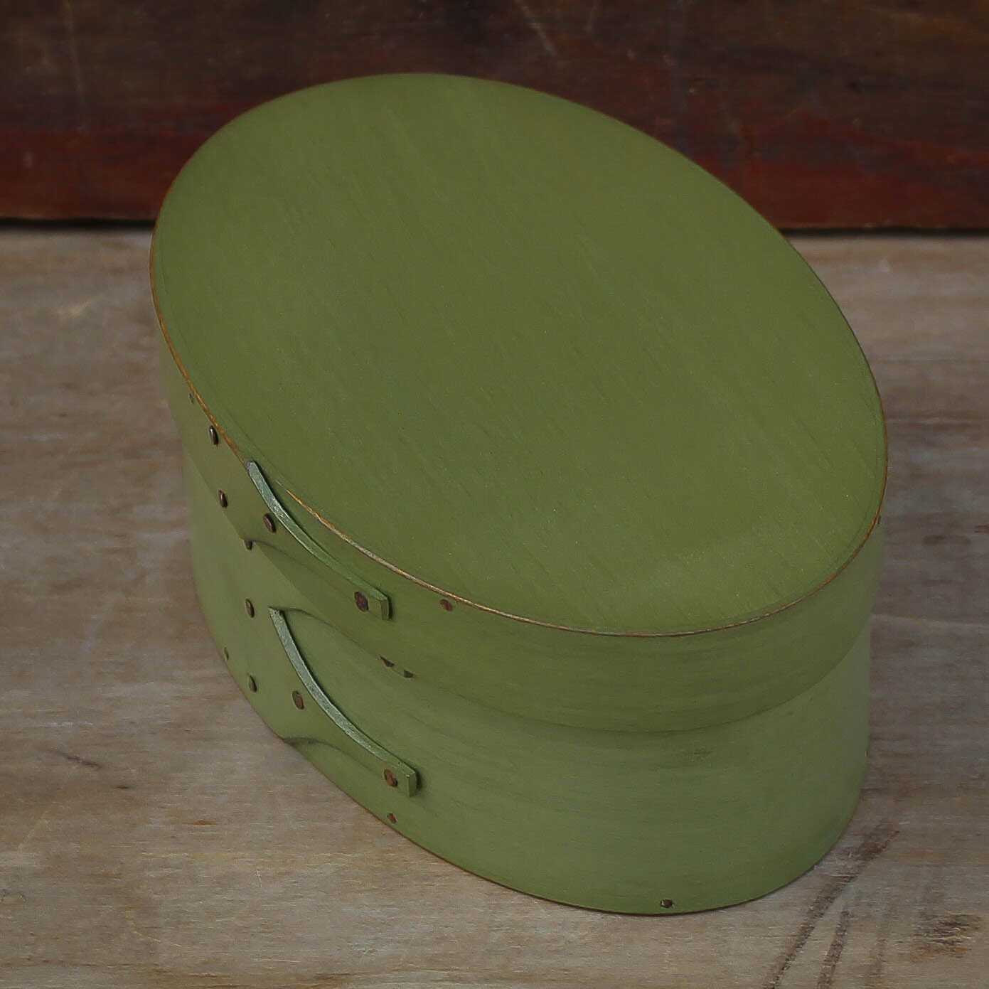 Handcrafted wooden oval shaker box in green, perfect for needlework and sewing projects, made in Maine.