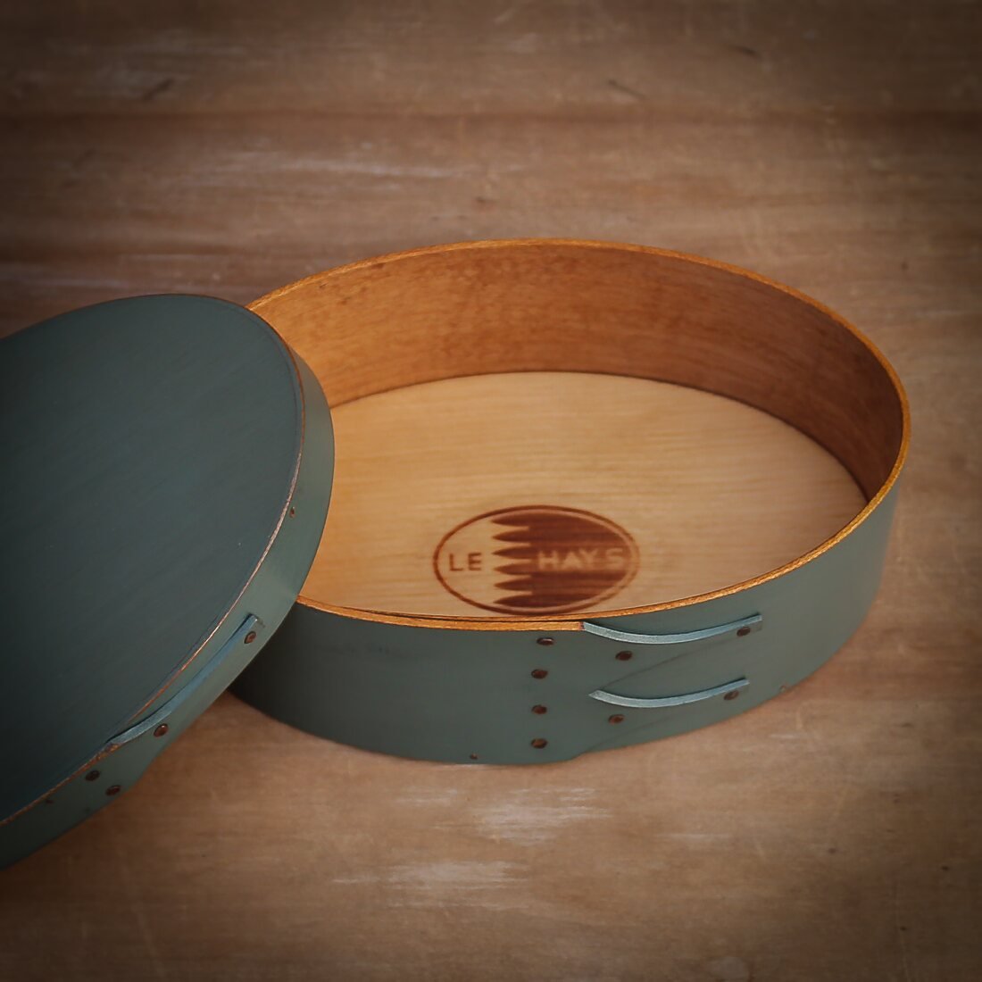 Handcrafted wooden oval shaker box from Maine, ideal for sewing and needlework storage.