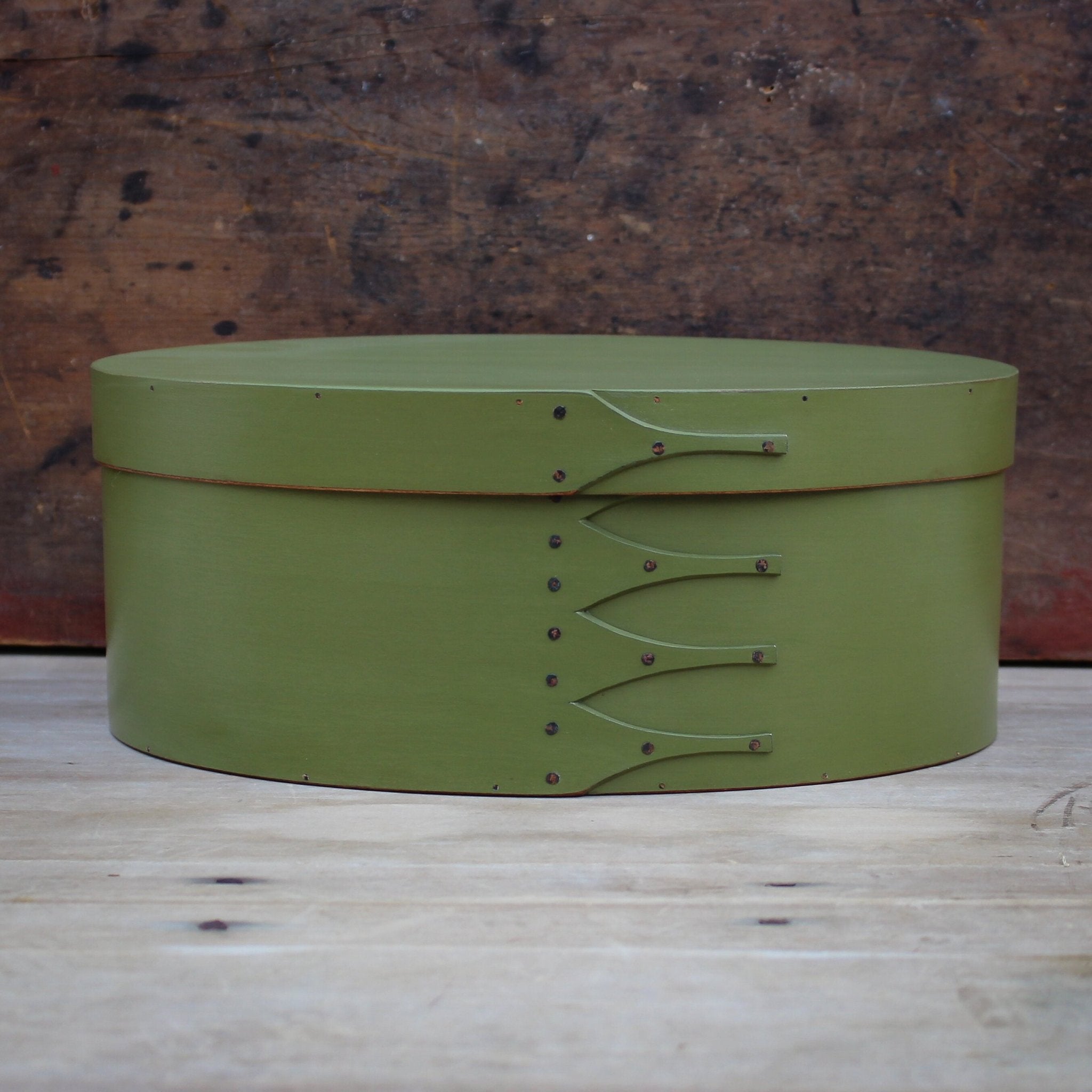 Handcrafted green wooden oval Shaker box from Maine, ideal for sewing and needlework storage.